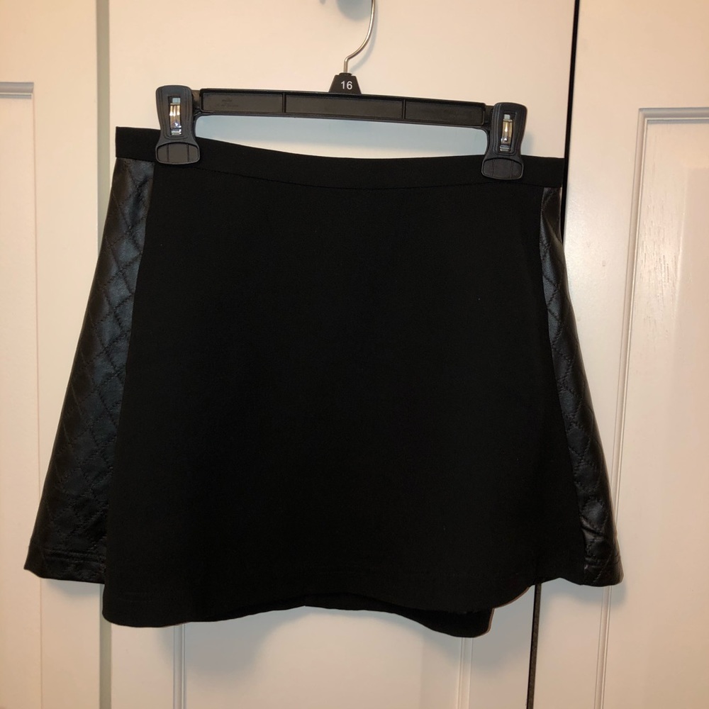 Black mini skirt. Faux leather details.
